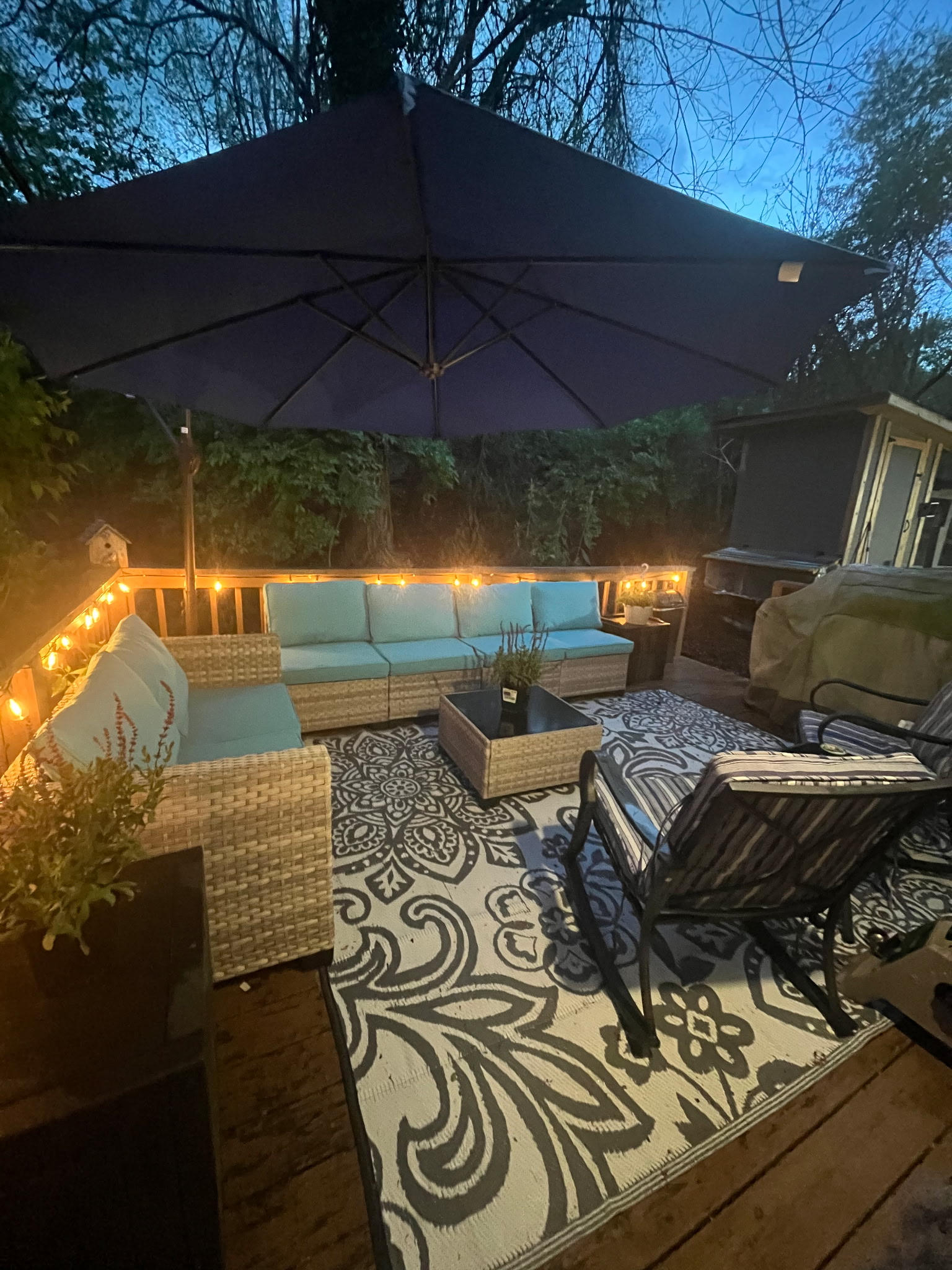 A deck with string lights and outdoor furniture