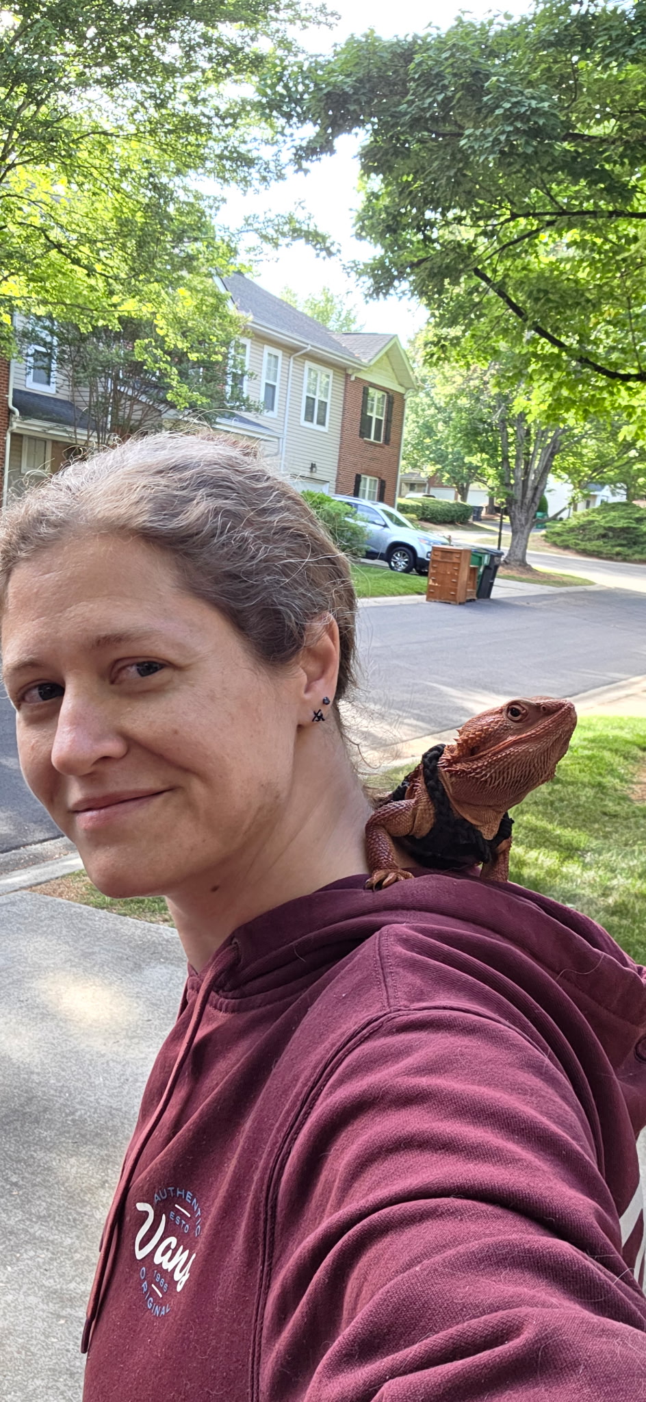 Amanda outdoors in a burgundy hoodie with a lizard on her shoulder